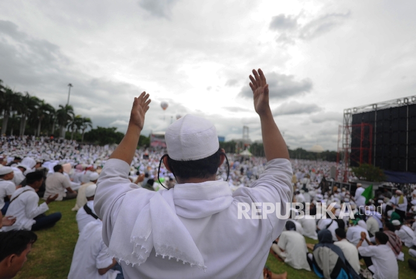 Umat muslim berdoa saat mengikuti aksi damai di kawasan Monas, Jakarta, Jumat (2/12)