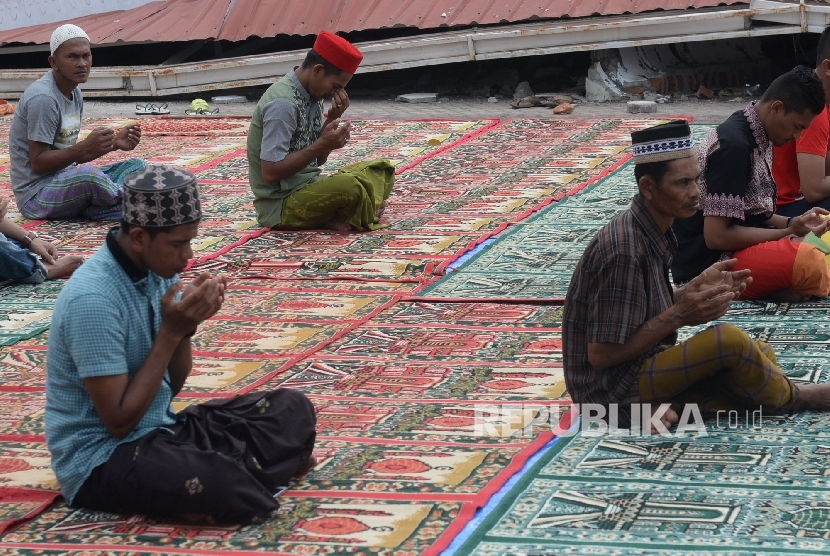 Umat muslim berdoa usai menunaikan Shalat Jumat di Masjid Jamik Quba, Pidie Jaya, NAD, Jumat (9/12).