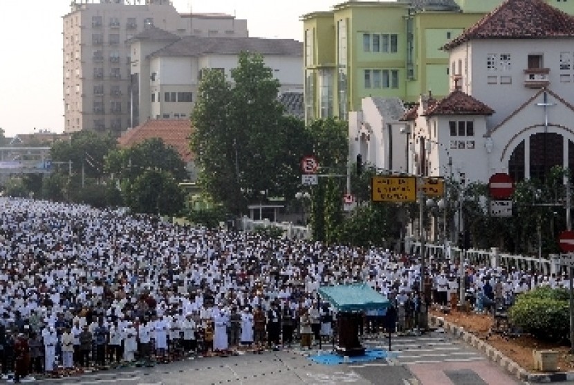 Umat muslim melaksanakan shalat Idul Adha 1433 H di simpang Jalan Matraman Raya, Jakarta Timur, Jumat (26/10).