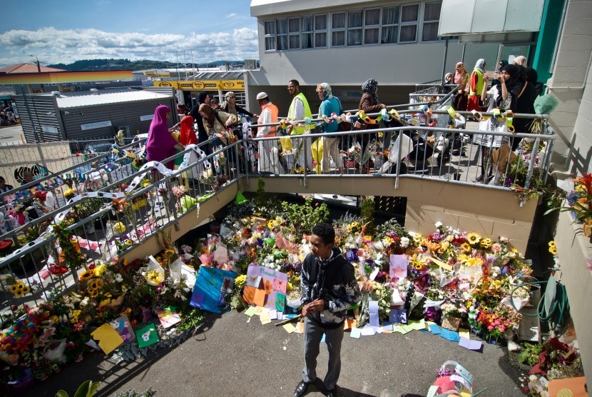 Umat muslim melintasi karangan bunga yang diletakkan warga di depan Masjid Wellington saat pelaksanaan salat Jumat pertama pascapenembakan di dua masjid kota Christchurch pada Jumat (15/3) di Kilbirnie, Wellington, Selandia Baru, Jumat (22/3/2019).