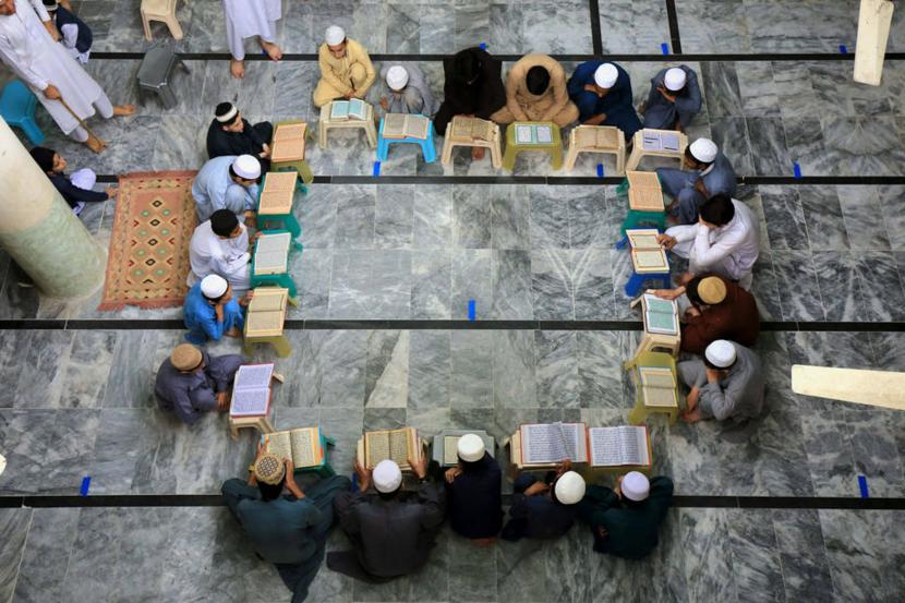  Umat muslim membaca Alquran di sebuah Masjid di Peshawar, Pakistan, Senin (4/5). Provinsi Khyber Pakhtunkhwa, Pakistan menetapkan masa lockdown akibat pandemi COVID-19 ditengah bulan suci Ramdan namun tidak berdampak pada aktivitas beribadah seperti membaca Alquran untuk mendapatkan pahala.  