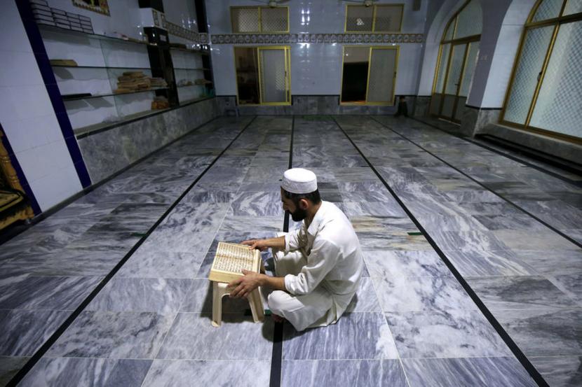 Tafsir Surat Al 'Alaq 1-3. Foto:  Umat muslim membaca Alquran di sebuah Masjid di Peshawar, Pakistan, Senin (4/5).  