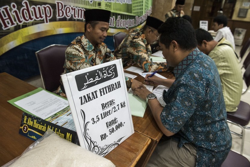 Umat muslim membayarkan zakat fitrah kepada panitia amil zakat (Ilustrasi)