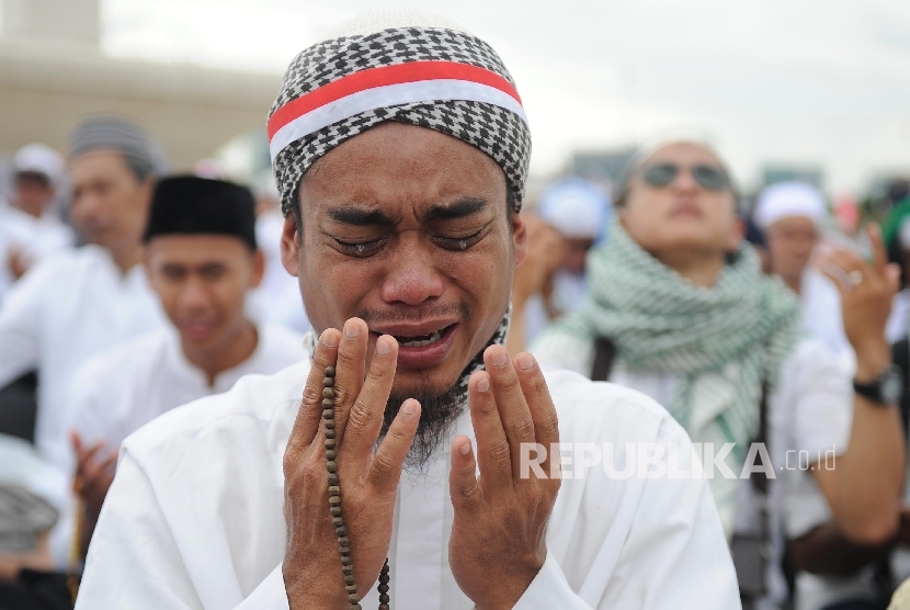 Umat muslim menangis saat berdoa di acara aksi damai di kawasan Monas, Jakarta, Jumat (2/12).