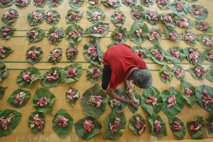 Umat muslim menata daging kurban di atas daun jati sebelum didistribusikan saat perayaan Idul Adha.