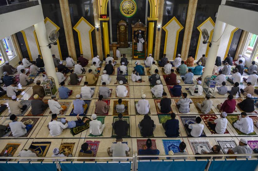 Umat muslim mendengarkan khotbah usai melaksanakan shalat Idul Fitri dengan pengaturan jarak di Masjid Al-Ikhlas, Palu, Sulawesi Tengah, Ahad (24/5/2020). DMI Sulteng Gelar Pelatihan untuk Imam dan Dai