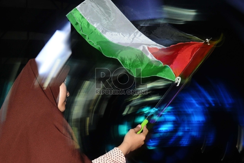 Umat muslim mengibarkan bendera saat mengikuti hari perayaan Palestine Solidarity Day (PSD) di Istora Senayan, Jakarta, Ahad (29/11). PSD merupakan peringatan sekaligus penolakan masyarakat atas tragedi pembagian Palestina berdasarkan PBB no 181.