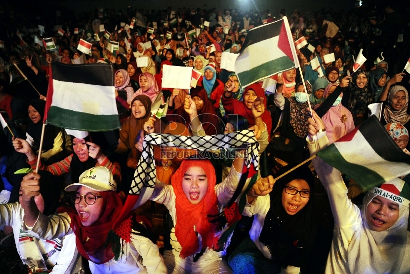 Umat muslim mengibarkan bendera saat mengikuti hari perayaan Palestine Solidarity Day (PSD) di Istora Senayan, Jakarta, Ahad (29/11).