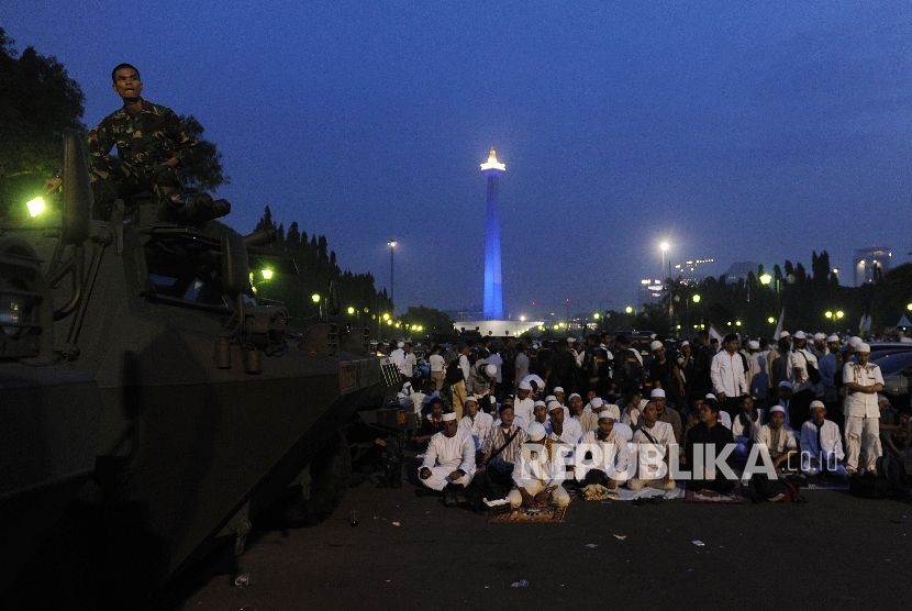 Umat muslim seusai menunaikan solat magrib di monas, Jakarta, Jumat (4/11)