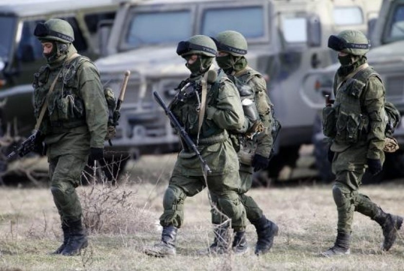 Uniformed men, believed to be Russian servicemen, walk near a Ukrainian military base in the village of Perevalnoye, outside Simferopol, March 6, 2014.