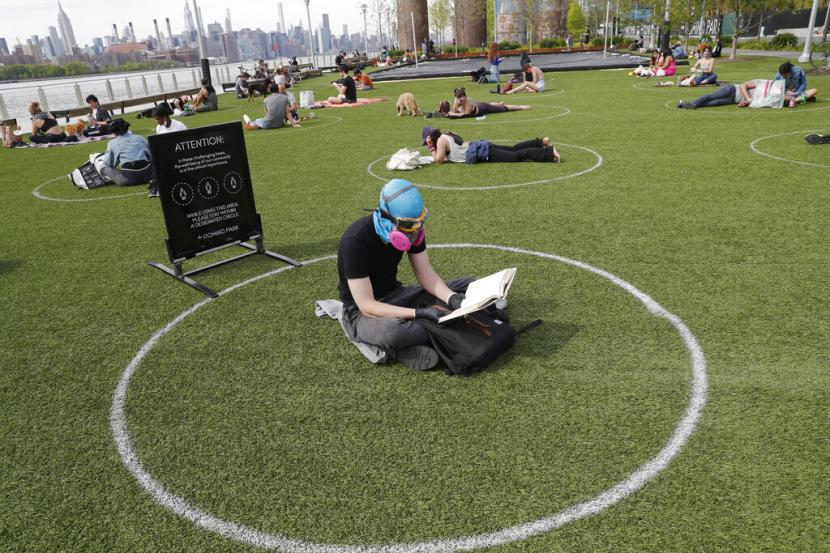 Taman di Kota New York Dihiasi Lingkaran Jarak,.Ridley Goodside duduk di dalam lingkaran di Domino Park, New York, Senin (18/5). Ruang publik perlu didesain agar sesuai dengan kondisi masyarakat saat pandemi. Ilustrasi.
