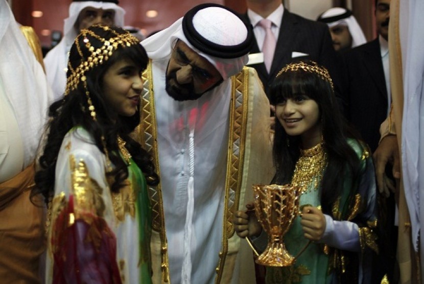 United Arab Emirates' Vice President and Prime Minister and Ruler of Dubai Sheikh Mohammed bin Rashid al-Maktoum (C) talks to girls in traditional dress during the opening of the Arabian Travel Market show in Dubai. ATM is held from April 30 to May 3. 