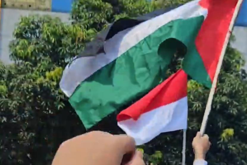 Mengibarkan bendera Palestina sebagai dukungan negara tersebut untuk merdeka.