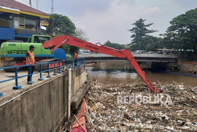 UPK Badan Air Dinas Lingkungan Hidup DKI Jakarta menangani sampah yang menumpuk di Pintu Air Manggarai, Jakarta Pusat, Senin (12/11).