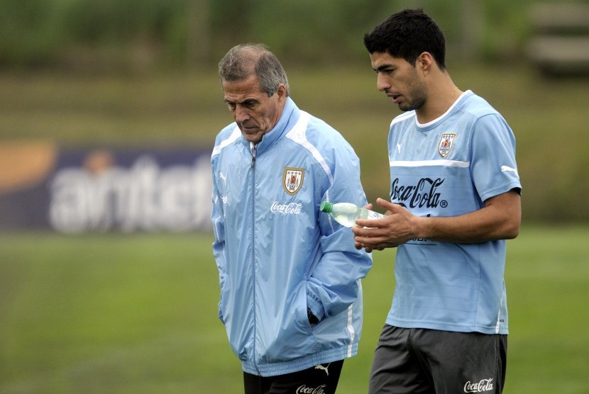 Uruguay coach Oscar Tabarez, left, and striker Luis Suarez walk together on the pitch after a training session on the outskirts of Montevideo, Tuesday, Oct. 9, 2012. Uruguay will face Argentina in a World Cup 2014 qualifying soccer game on Friday.