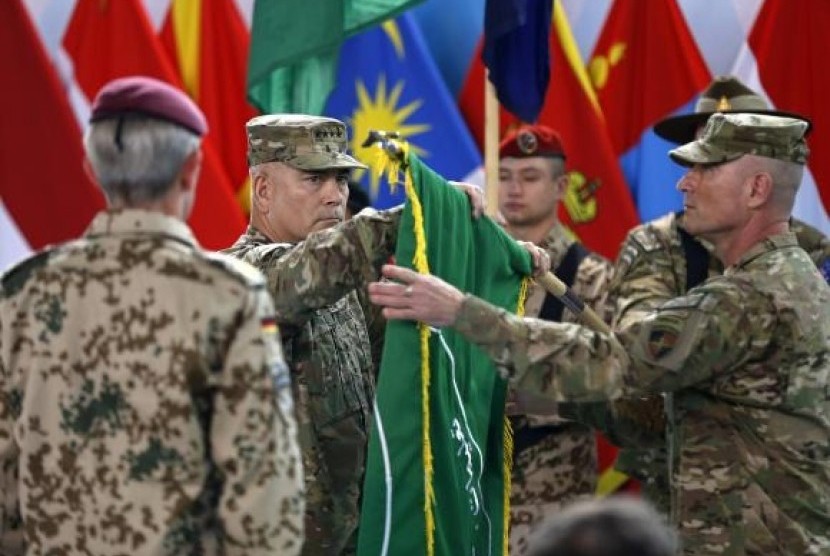 US General John Campbell (center), commander of NATO-led International Security Assistance Force (ISAF), folds the flag of the ISAF during the change of mission ceremony in Kabul, December 28, 2014. 