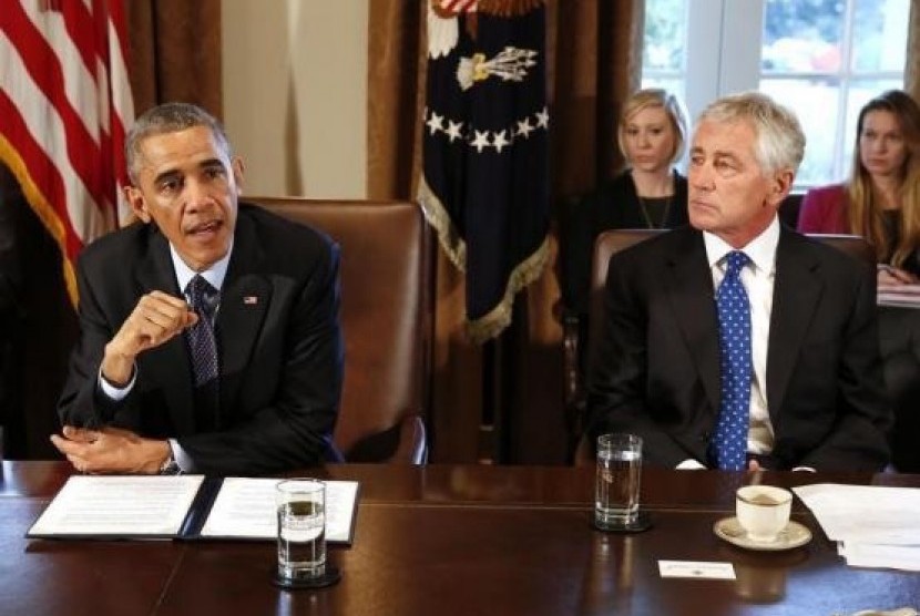 US President Barack Obama (left) speaks as Secretary of Defense Chuck Hagel listens before the start of a Cabinet Meeting in the Cabinet Room at the White House in Washington, November 7, 2014.