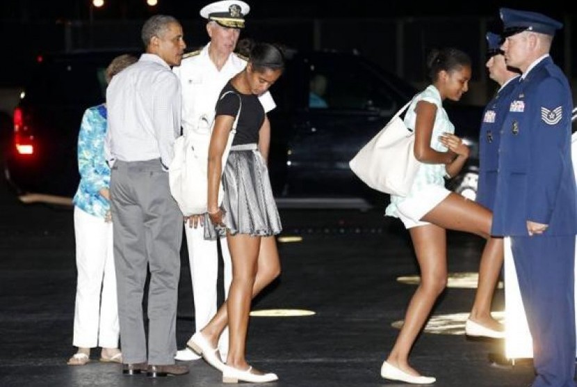 US President Barack Obama (second left) and his daughters Malia (center) and Sasha (third right) board Air Force One upon their departure from Honolulu to return to Washington after a two-week vacation in Hawaii January 4, 2014.