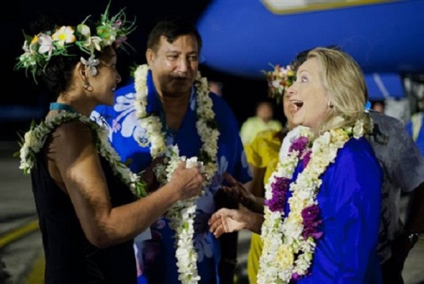 US Secretary of State Hillary Rodham Clinton, right, reacts as she attends an arrival ceremony at Rarotonga International Airport in Rarotonga, Cook Islands, Thursday, Aug. 30, 2012. Clinton arrived Thursday in the South Pacific at the top of a six-nation 