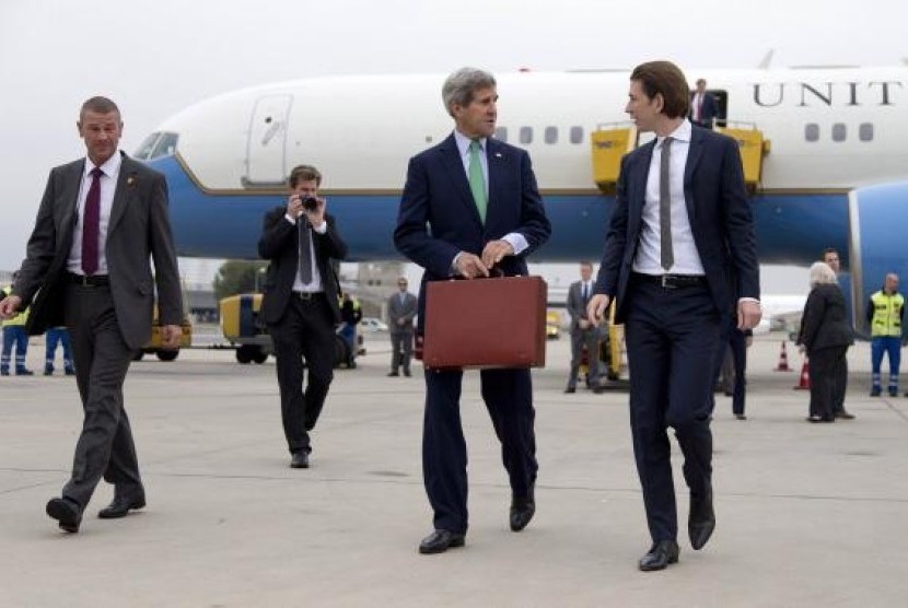 US Secretary of State John Kerry (center) walks to his car with Austria's Foreign Minister Sebastian Kurz (right) as he arrives at Vienna International Airport, in Vienna October 15, 2014.