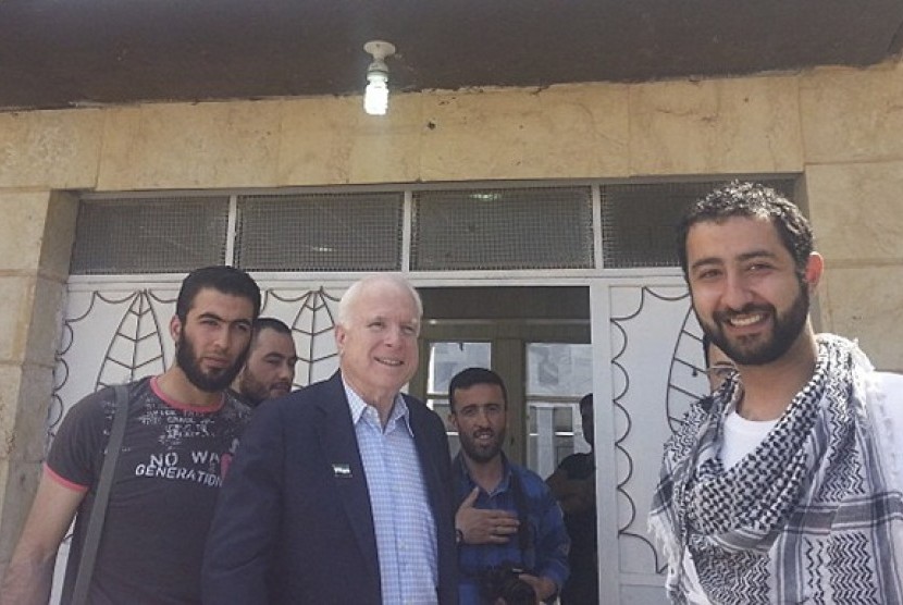 US Senator John McCain (middle), an outspoken advocate for US military aid to the Syrian opposition, meets with Free Syrian Army fighters and SETF Executive Director Mouaz Moustafa (right) during a surprise visit to Syria in this May 27, 2013 handout photo