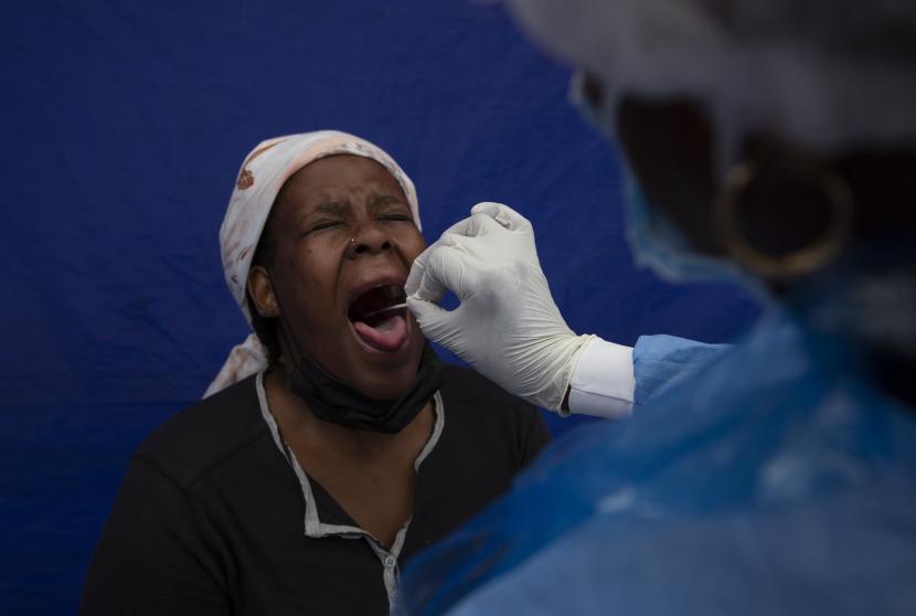 Usap tenggorokan diambil dari seorang pasien untuk tes COVID-19 di sebuah fasilitas di Soweto, Afrika Selatan, Rabu 2 Desember 2021. Afrika Selatan telah mempercepat kampanye vaksinasinya dengan memberikan suntikan di situs pop-up di pusat perbelanjaan dan transportasi pusat untuk memerangi kasus baru COVID-19 yang meningkat pesat.