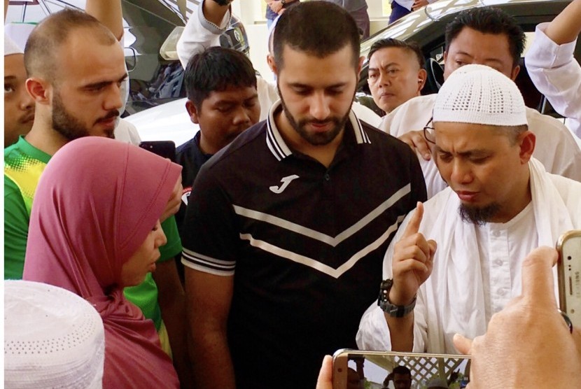 Ustadz Muhammad Arifin Ilham (kanan) membimbing Anna Veronica mengucapkan dua kalimat syahadat.