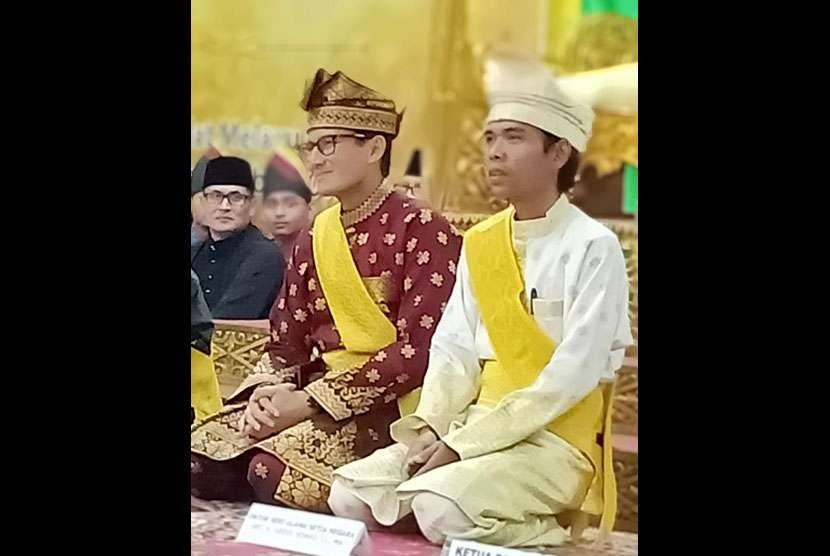 Ustaz Abdul Somad duduk disamping Sandiaga Uno saat menerima gelar adat dari Lembaga Adat Melayu Riau, di Pekanbaru (4/9).