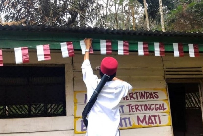 Ustaz Abdul Somad memasang bendera merah putih di rumah di permukiman Suku Talang Mamak, pedalaman Riau.