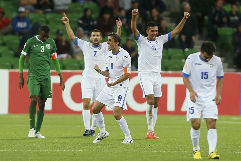 Uzbekistan's players celebrate after winning their Asian Cup Group B soccer match against Saudi Arabia at the Rectangular stadium in Melbourne January 18, 2015