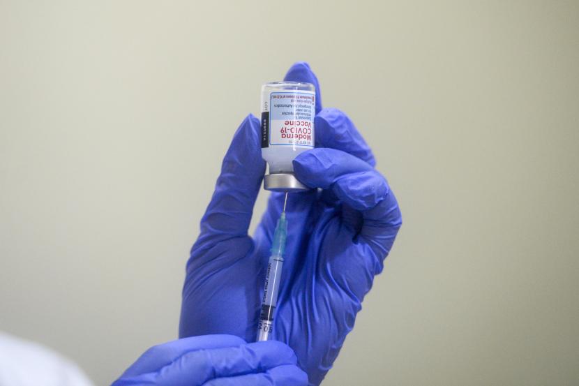 Vaksinator memasukan dosis vaksin Moderna, ilustrasi