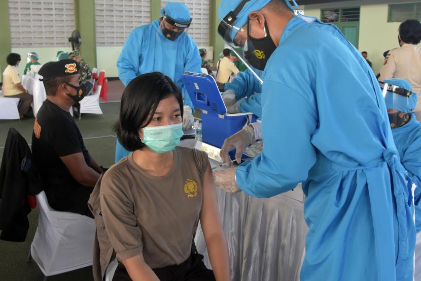 Vaksinator menyuntikkan vaksin COVID-19 kepada anggota Polisi saat vaksinasi anggota TNI-Polri di Kesatrian Praja Raksaka Kepaon (Kodam IX/Udayana), Denpasar, Bali, Jumat (19/3/2021). Kegiatan yang digelar serentak di Bali, NTB dan NTT tersebut diikuti 3.112 anggota TNI-Polri untuk mendukung program vaksinasi nasional guna menekan angka penyebaran COVID-19.
