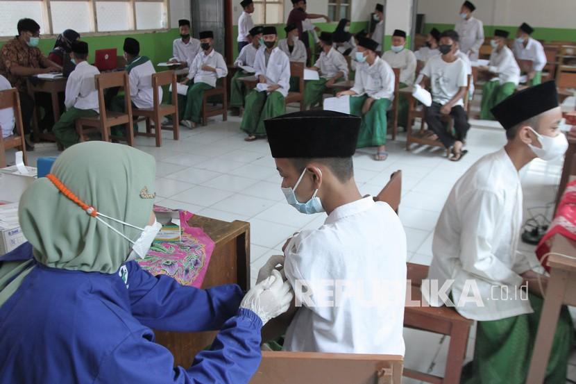 Vaksinator menyuntikkan vaksin COVID-19 kepada santri saat vaksinasi massal di Pesantren Al-Ikhlas, Tanjungpura, Karawang, Jawa Barat, Kamis (30/9/2021). Pemerintah Provinsi Jawa Barat menargetkan sebanyak tiga juta santri menerima vaksin COVID-19 dari jumlah total 12 ribu pesantren di Jawa Barat. 