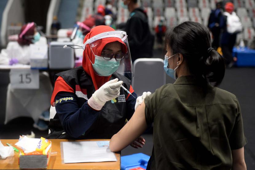 Vaksinator menyuntikkan vaksin COVID-19 kepada tenaga kesehatan saat kegiatan vaksinasi massal di Istora Senayan, Jakarta, Kamis (4/2). Pusat Pengendalian dan Pencegahan Penyakit Amerika Serikat (CDC) mengungkapkan setidaknya ada beberapa potensi efek samping yang mungkin dilami setelah vaksinasi.  