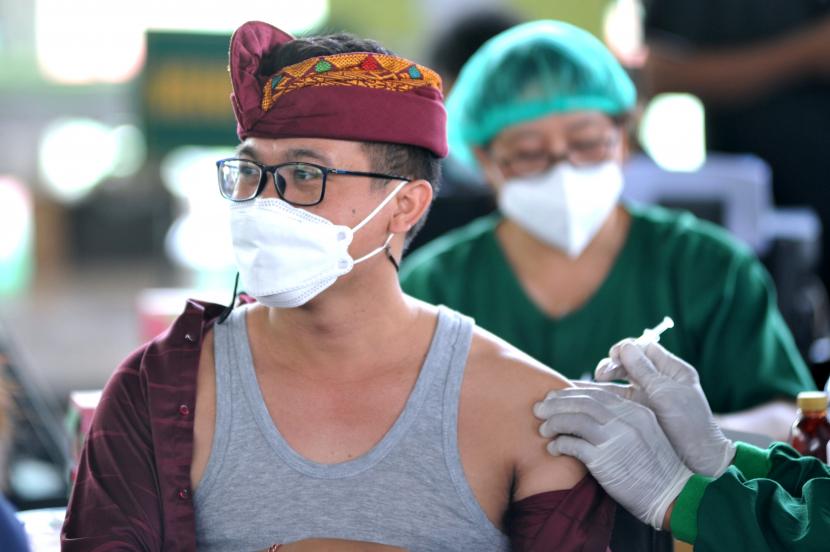 Vaksinator menyuntikkan vaksin COVID-19 kepada warga saat pelaksanaan vaksinasi COVID-19 massal di Denpasar, Bali.