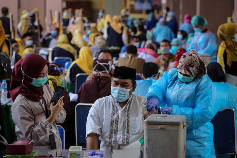 Vaksinator menyuntikkan vaksin COVID-19 Sinovac ke seorang guru saat vaksinasi massal di Gedung Pemerintah Kota Tangerang, Banten, Kamis (25/2/2021). Sebanyak 6.000 petugas pelayanan publik dan guru di Kota Tangerang menjalani vaksinasi COVID-19 yang dilaksanakan hingga satu minggu ke depan
