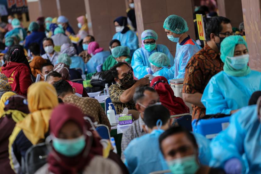 Vaksinator menyuntikkan vaksin COVID-19 Sinovac ke seorang guru saat vaksinasi massal di Gedung Pemerintah Kota Tangerang, Banten, Kamis (25/2/2021). Sebanyak 6.000 petugas pelayanan publik dan guru di Kota Tangerang menjalani vaksinasi COVID-19 yang dilaksanakan hingga satu minggu ke depan.