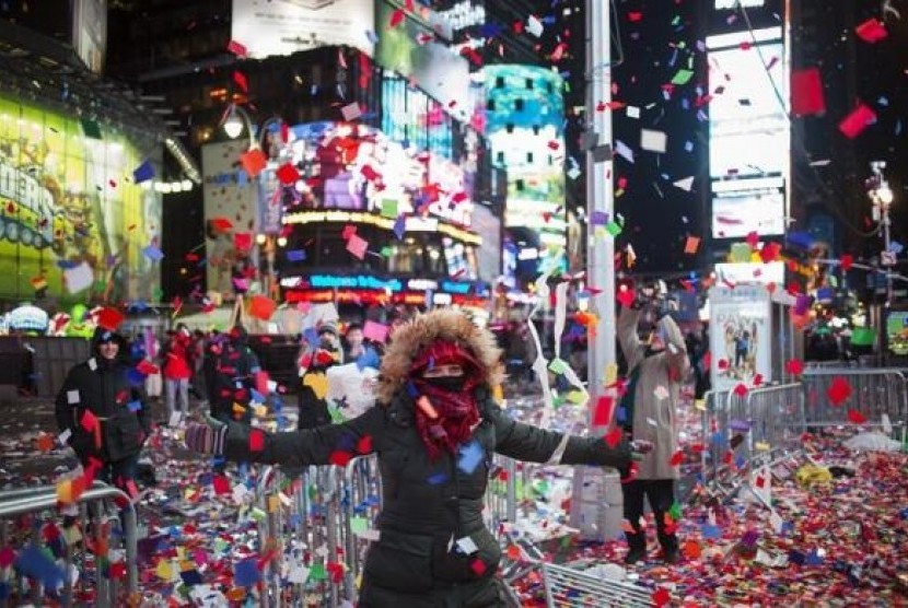 Valentina Guazzolini, of Ravenna, Italy, plays in confetti which was scattered by a gust of wind into the air after New Year celebrations in Times Square, Midtown, New York January 1, 2014. 
