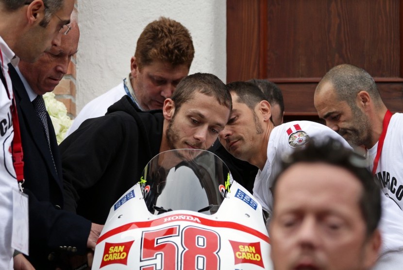 Valentino Rossi memegangi motor almarhum Marco Simoncelli saat upacara pemakaman di Rimini, Italia, 27 Oktober 2011.