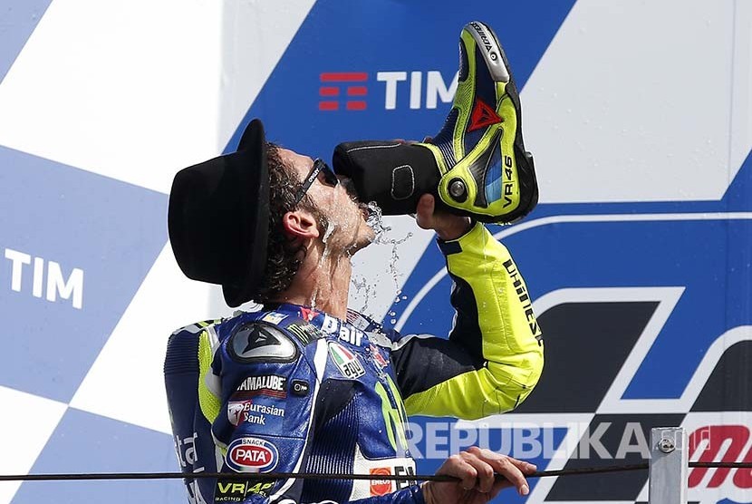 Valentino Rossi minum menggunakan sepatu boot-nya di podium  Balapan MotoGP San Marino 2016