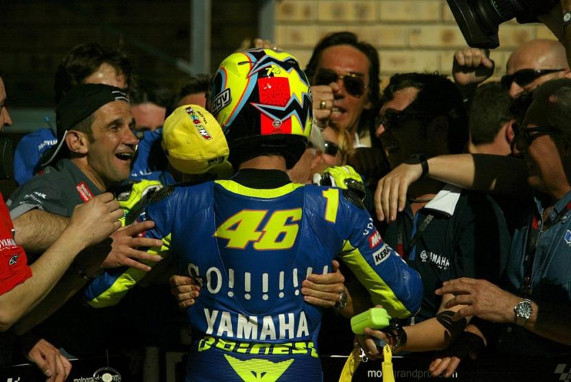 Pembalap asal Italia, Valentino Rossi (tengah). dipeluk oleh kru di tim Yamaha setelah memenangi balapan di Afrika Selatan pada MotoGP 2004.