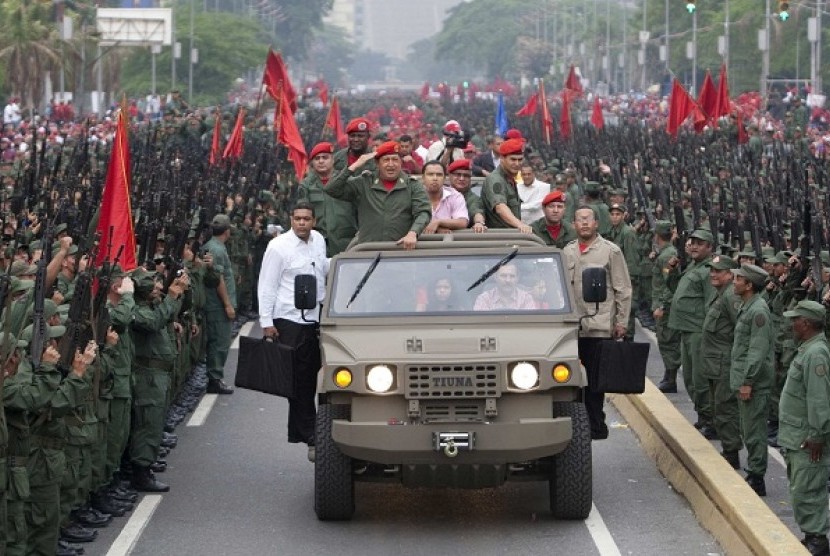Venezuela's President Hugo Chavez salutes militia members as he arrives for a ceremony to commemorate the eighth anniversary of his return to power after a brief coup, in Caracas in this April 13, 2010 file photo. 