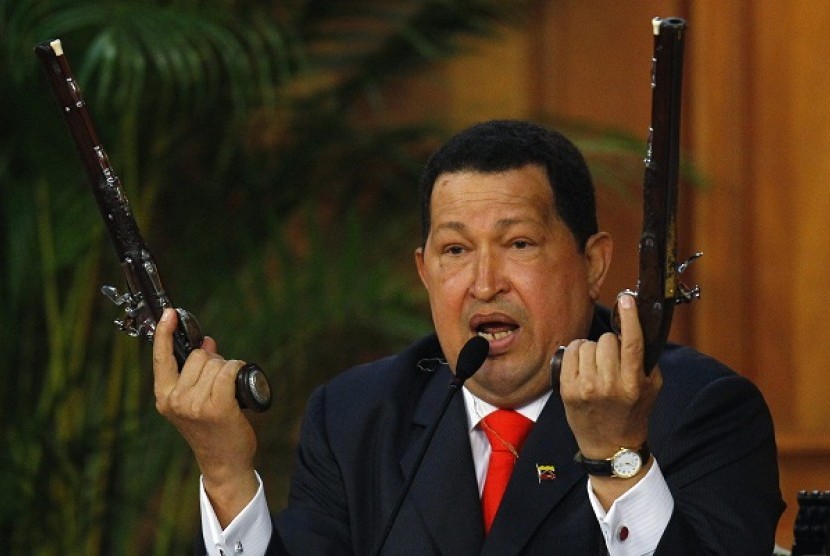 Venezuela's President Hugo Chavez shows the pistols of independence hero Simon Bolivar during a ceremony to mark the his birthday in Caracas in this July 24, 2012.