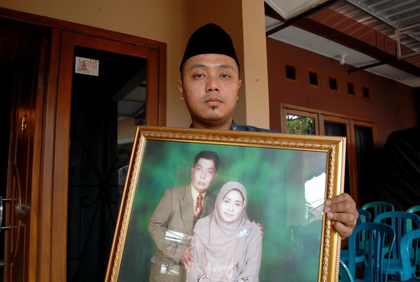   Vicky Madya memperlihatkan foto kedua orangtuanya Wisma Widyana Puspitasari (51) dan Ferryza Gani (55) yang menjadi korban tragedi Mina di rumahnya Jalan Belibis, Perumahan Cimahpar II, Sukaraja, Sukabumi, Jawa Barat, Selasa (29/9). 