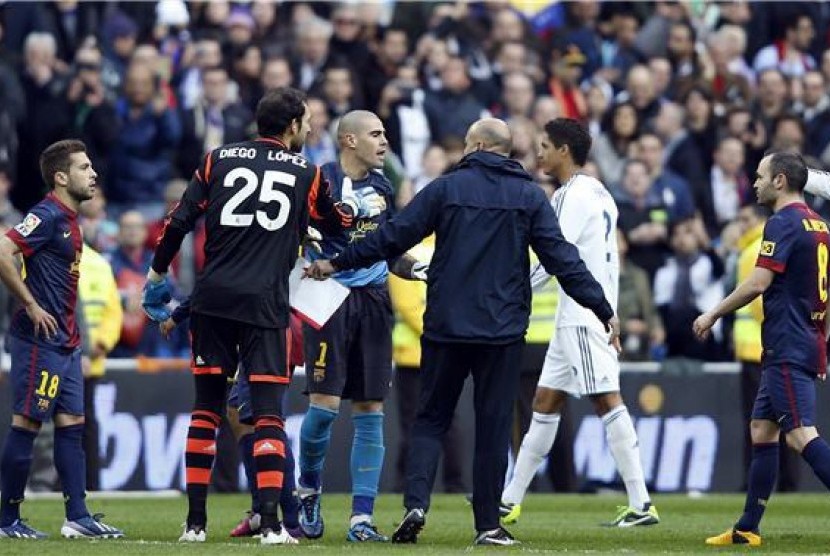 Victor Valdes (tengah), kiper Barcelona, memprotes keputusan wasit saat menghadapi Real Madrid di laga La Liga di Santiago Bernabeu, Madrid, Sabtu (2/3).