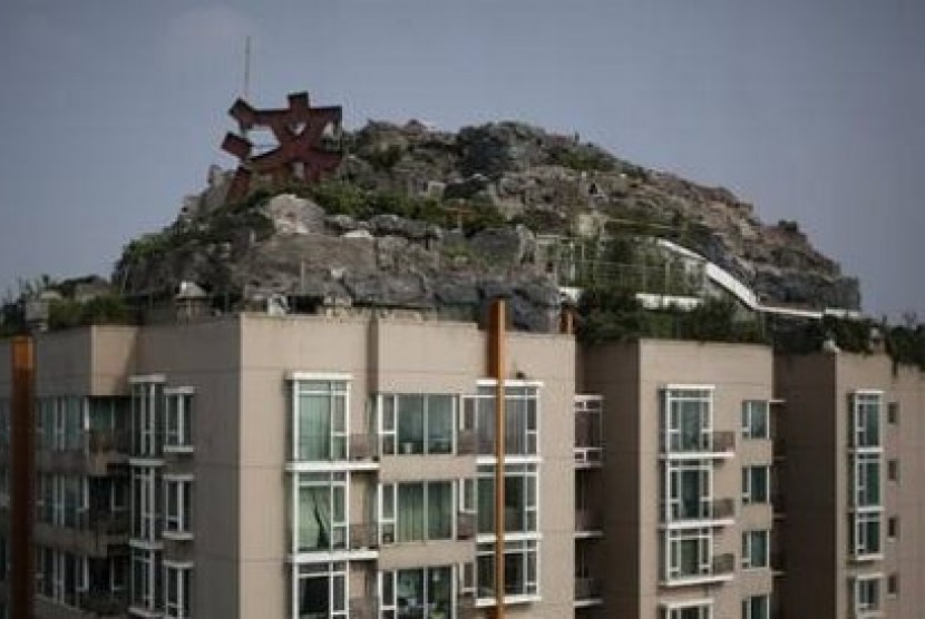 Vila di tengah bebatuan, pepohonan dan semak di atas apartemen setinggi 26 lantai di Beijing, Cina.