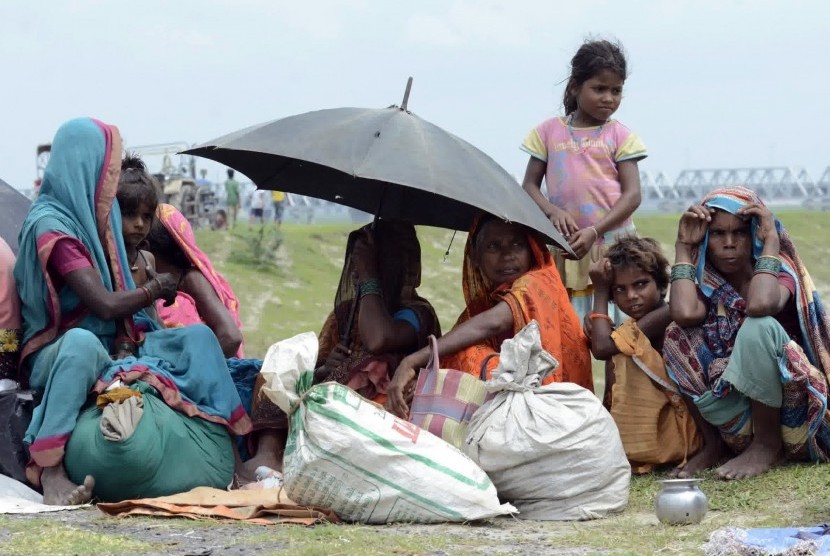 Villagers with their belongings sit in a relief camp after their evacuation at Supaul district in the eastern Indian state of Bihar August 3, 2014. More than 400,000 people in eastern India face the risk of flooding after a landslide that killed at least n