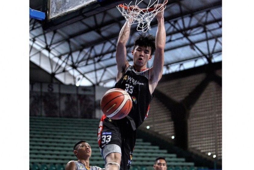 Vincent Rivaldi Kosasih melakukan dunk saat menghadapi Satya Wacana Salatiga dalam laga pembuka Seri I Pertalite IBL 2017.