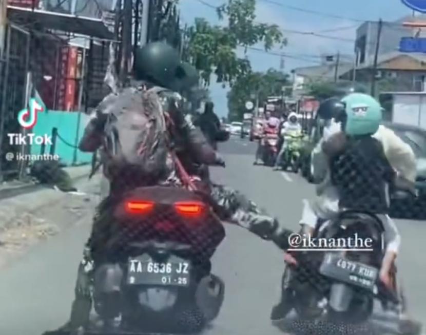 Viral pengemudi mengenakam seragam loreng diduga personel TNI AD menendang pengemudi motor seorang ibu membonceng anaknya.