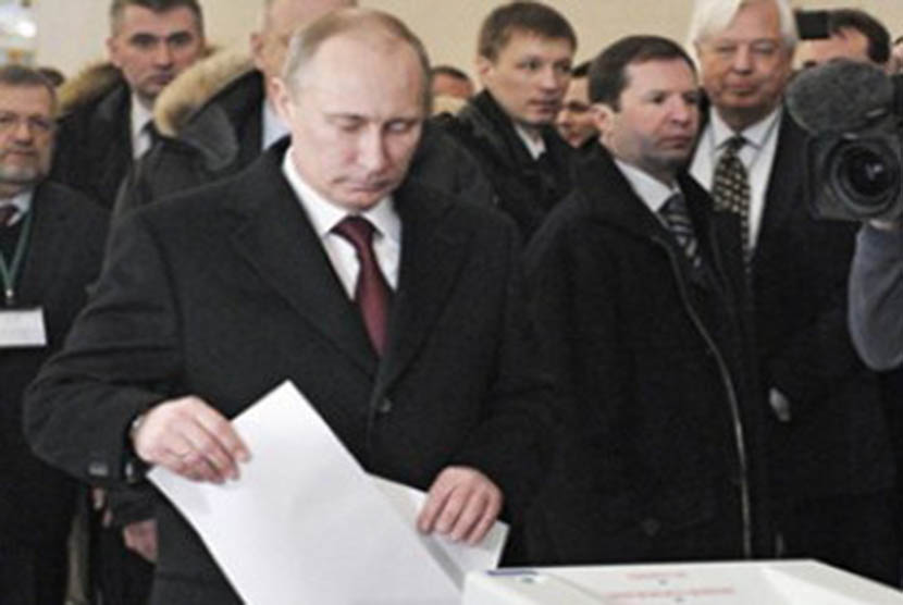 Vladimir Putin memasukkan surat suara ke kotak suara pada Pemilu Rusia 2012. (ilustrasi)